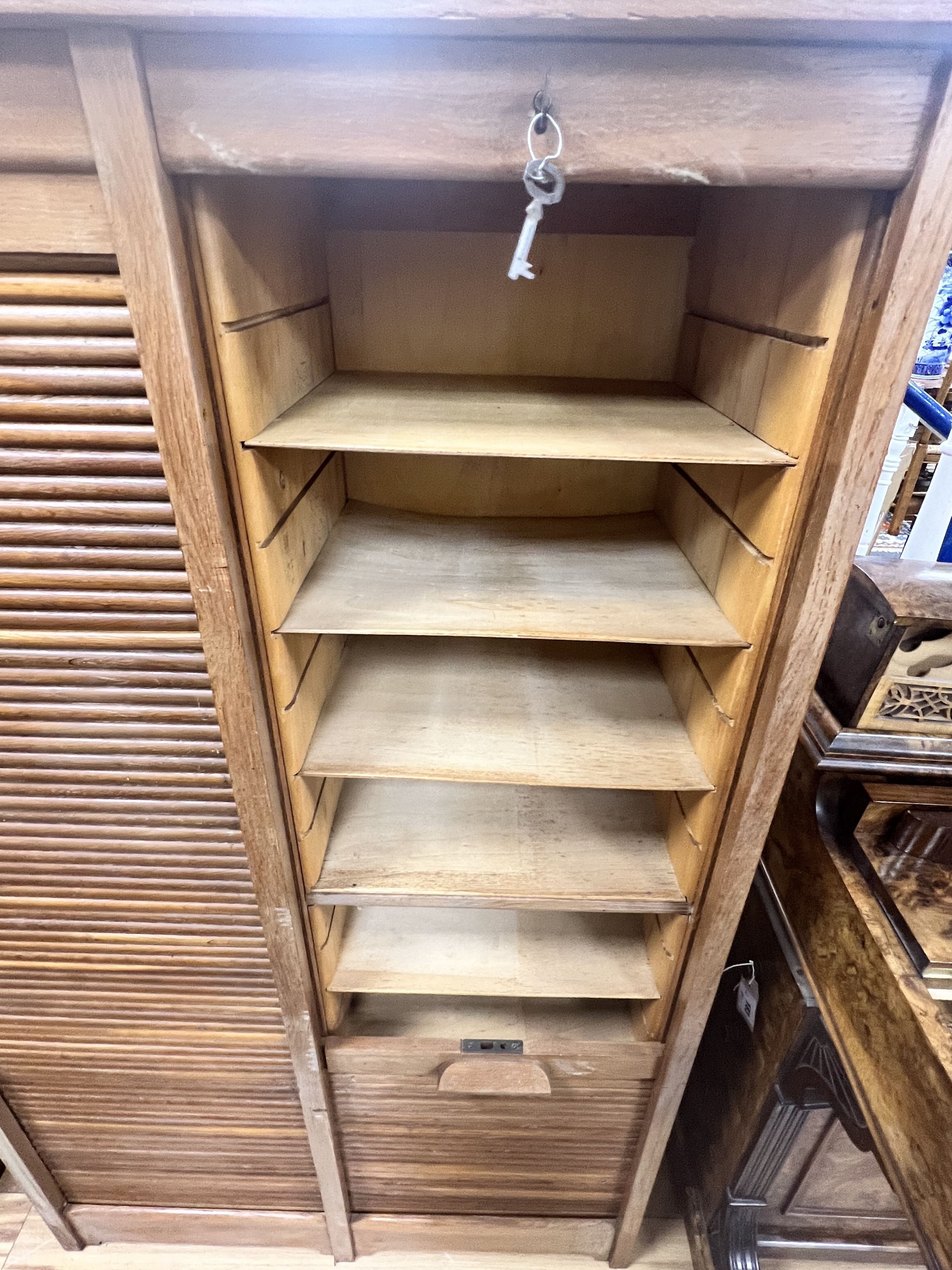 A mid century oak double tambour filing cabinet, width 87cm depth 38cm height 143cm